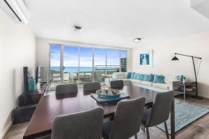 Un comedor con una mesa y sillas y un sofá. en Point Grey Apartment 13, en Lorne
