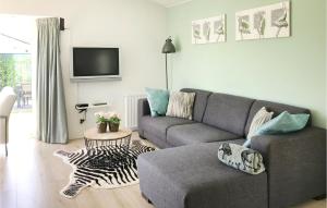 sala de estar con sofá y TV en Amazing Home In Molenschot With House Sea View, en Molenschot