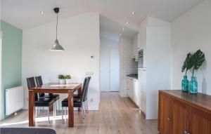 a kitchen and dining room with a table and chairs at Amazing Home In Molenschot With House Sea View in Molenschot