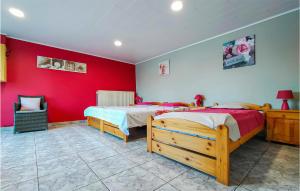 a bedroom with two beds and a red wall at Nadrin O Vert in Nadrin