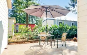 a table and chairs with an umbrella on a patio at Pet Friendly Home In Vorden With Kitchen in Vorden