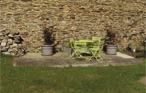 a green table and chairs next to a stone wall at Nadrin O Vert in Nadrin