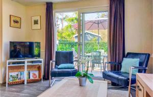 een woonkamer met stoelen en een televisie en een patio bij Pet Friendly Home In Vorden With Kitchen in Vorden