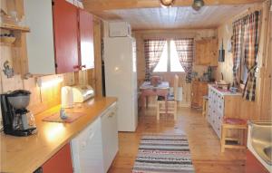 eine Küche mit einem Kühlschrank und einem Tisch im Zimmer in der Unterkunft Mnebu in Tunhovd