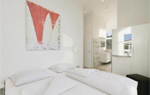 トラフェミュンデにあるDnenvilla Penthouseの白いソファ付きの白いベッドルームと壁に絵画が飾られています。