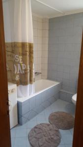 a bathroom with a tub and a shower curtain at ELIA COZY HOUSE in Paleo Tsifliki