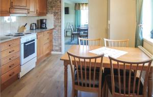 a kitchen with a wooden table with chairs and a stove at Beautiful Home In Vessigebro With Sauna in Vessigebro