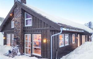 a log cabin in the snow with snow at Nice Home In Rauland With Sauna in Torvetjørn