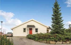 VestvikにあるNice Home In Auklandshamn With 4 Bedrooms, Sauna And Wifiの赤い扉と松の木のある白い家
