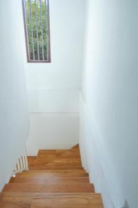 a stairway with a window in a white room at Djuragan Kamar Ayem in Jetis