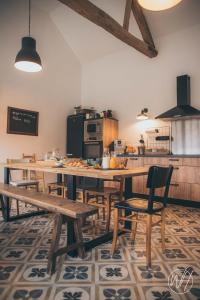 a kitchen with a large wooden table and chairs at L'Escale Bellifontaine in Ury