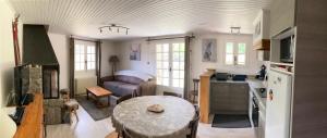 a kitchen and living room with a table and a couch at la grange T2 Centre Ville Jardin WIFI in Formiguères