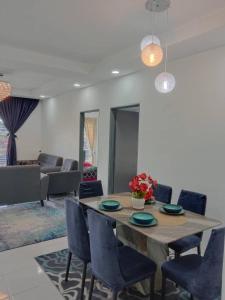 ein Esszimmer mit einem Tisch und blauen Stühlen in der Unterkunft Ramadhina Eagle Eye View Home2stay Emerald Avenue in Brinchang