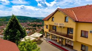 uma vista para a frente de um hotel com uma árvore em Pension Bella Vista em Sighişoara