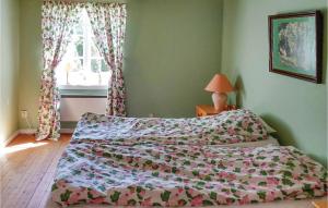 una camera da letto con un letto con un piumone e una finestra di Lovely Home In Motala With Wifi a Motala