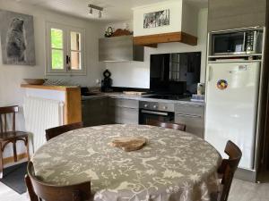 eine Küche mit einem Tisch und einem weißen Kühlschrank in der Unterkunft la grange in Formiguères