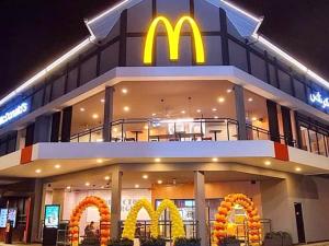 Um edifício Mcdonalds com um restaurante Mcdonalds à noite. em Ramadhina Eagle Eye View Home2stay Emerald Avenue em Brinchang