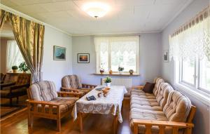 uma sala de estar com um sofá, uma mesa e cadeiras em 3 Bedroom Amazing Home In Vnersborg em Venersburgo