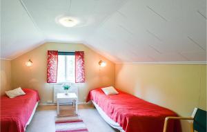 3 Bedroom Amazing Home In Vnersborg في فيرنيشبورغ: سريرين في غرفة بها أغطية حمراء ونافذة