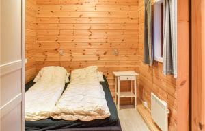 SjusjøenにあるBeautiful Home In Sjusjen With 3 Bedrooms And Wifiの小さなベッドルーム(木製の壁のベッド付)