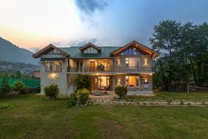 a large house with a green roof at SaffronStays Persimmon House, Raison - luxury villa with Baes river and paragliding point views in Grāmag