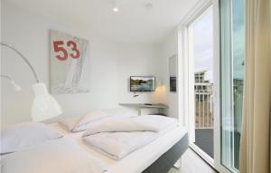 トラフェミュンデにあるDnenvillaの白い部屋で、ベッド2台、窓が備わります。