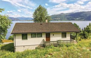a small white house with a lake in the background at Stunning Home In Balestrand With 2 Bedrooms in Tuve