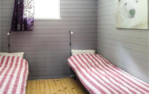 two beds in a room with gray walls at Raaen Hytteutleige 4 in Utne