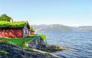 a house on the shore of a body of water at Raaen Hytteutleige 4 in Utne