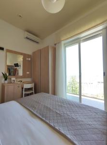 een slaapkamer met een groot bed en een groot raam bij Hotel Galassia in Rimini