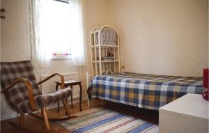 a small bedroom with a bed and a chair at Awesome Home In Lttorp With Wifi in Löttorp