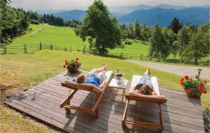 two people laying in lawn chairs on a wooden deck at Stunning Apartment In Mozirje With Kitchen in Mozirje