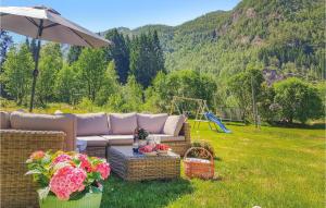 a couch sitting in the grass with a swing at 3 Bedroom Lovely Home In Vikanes in Eikemo
