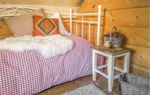 a bed with a red and white blanket and a table at 3 Bedroom Lovely Home In Vikanes in Eikemo