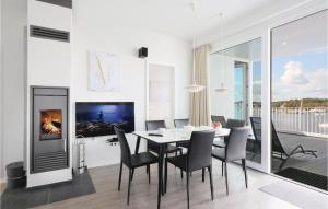 ein Esszimmer mit Tisch und Stühlen und einem Fernseher in der Unterkunft Priwallpromenade 2, Whg 11 in Travemünde