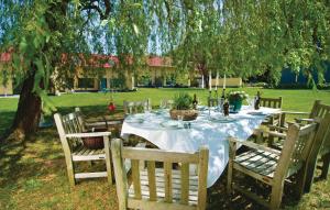 a table with a white table cloth on it with chairs at 2 Bedroom Lovely Home In Pinnow in Petersberg