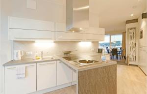 eine Küche mit weißen Schränken und einer Spüle in der Unterkunft Priwallpromenade 2, Whg 11 in Travemünde