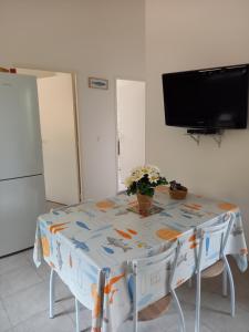 hébergement figari في فيغاري: مطبخ مع طاولة وتلفزيون على الحائط