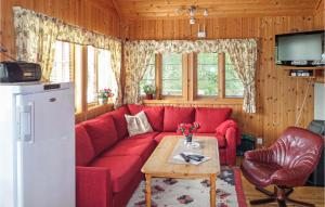 a living room with a red couch and a table at Stunning Home In Varaldsy With 3 Bedrooms And Wifi in Gjuvsland