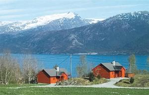 two red barns in front of a lake and mountains at Stunning Home In Varaldsy With 3 Bedrooms And Wifi in Gjuvsland