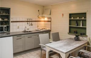 ヒンデローペンにあるDe Eekhof - Appartement Susanのキッチン(テーブル、椅子付)