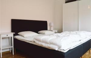 uma cama grande com lençóis brancos e almofadas em Amazing Apartment In Rnnng With 2 Bedrooms And Wifi em Rönnäng