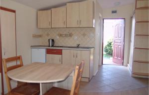 a kitchen with a wooden table and a table and chairs at Nice Home In Jaroslawiec With Wifi in Jarosławiec