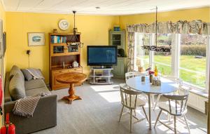 a living room with a table and a tv at Nice Home In Listerby With Wifi in Listerby