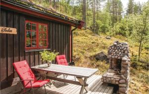 a wooden deck with a table and chairs outside a cabin at Awesome Home In Rendalen With Kitchen in Rendalen