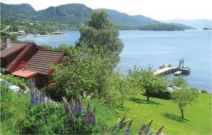 a house on the shore of a lake with a boat at Nice Home In Valen With Wifi in Valen +23 photos