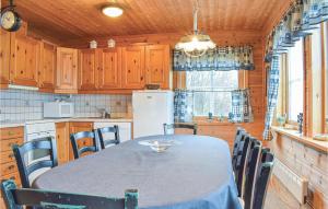 een keuken met een tafel met stoelen en een koelkast bij Sjidyll in Vaka