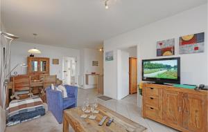 una sala de estar con TV en un centro de entretenimiento de madera en 2 Bedroom Gorgeous Apartment In Rechlin, en Rechlin 22 fotos más