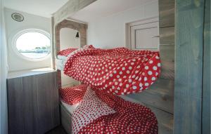 1 dormitorio con 2 camas con lunares rojos y blancos en Aquacabin, en Leimuiden