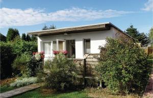 a small white house in a garden at Awesome Home In Insel Poel in Insel Poel